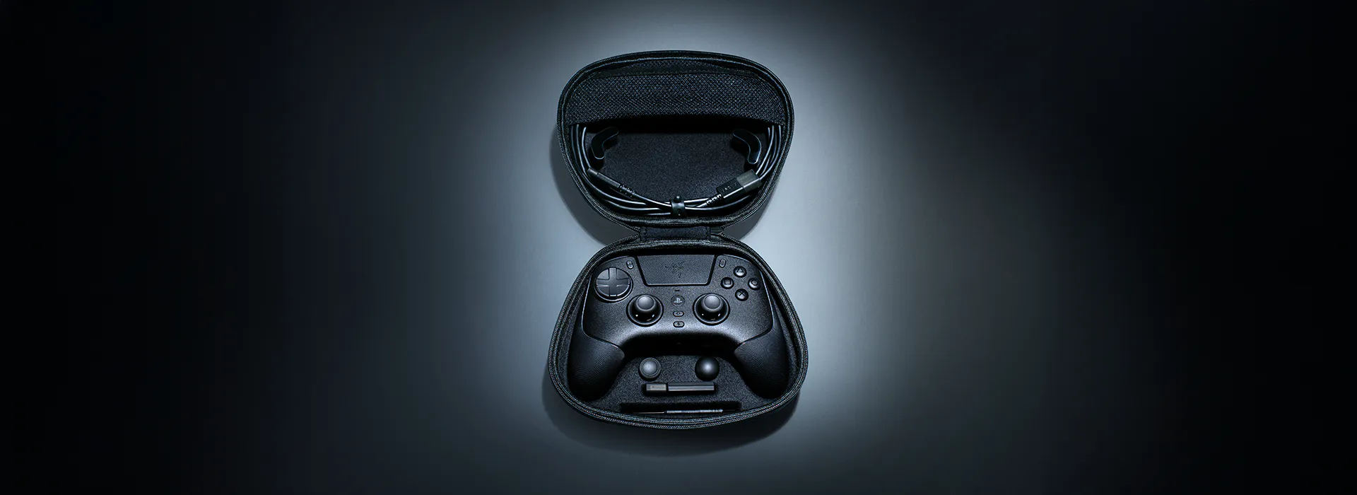 Open black case with a gaming controller and wired earphones inside, set against a dark gradient background.