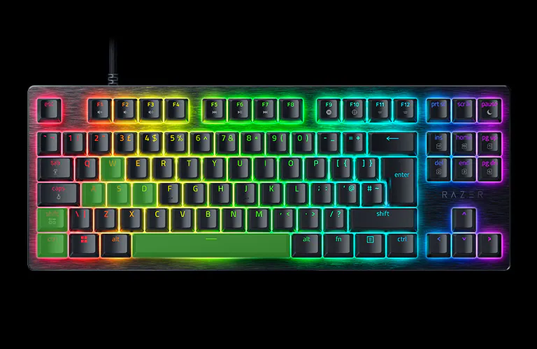 A RGB-backlit gaming keyboard on a black background, with illuminated keys in a rainbow pattern.