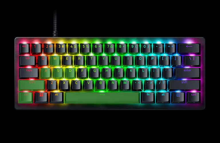 RGB backlit Razer keyboard glowing on a black background including green marked on keys WASD, L-shift, L-ctrl, and spacebar.