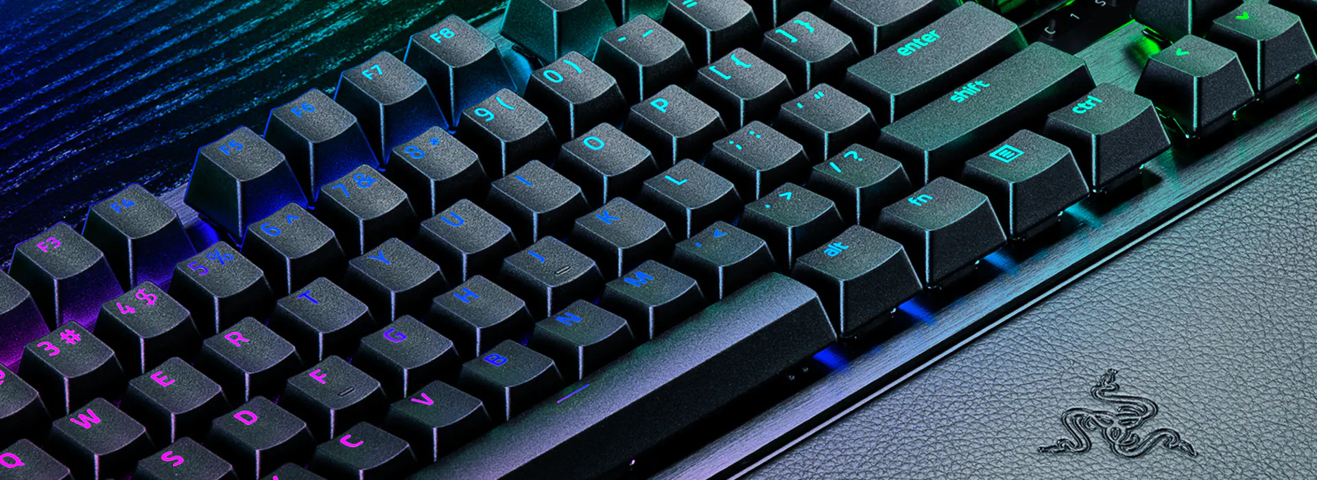 RGB backlit mechanical keyboard on a textured Razer mousepad with a black surface and textured logo.