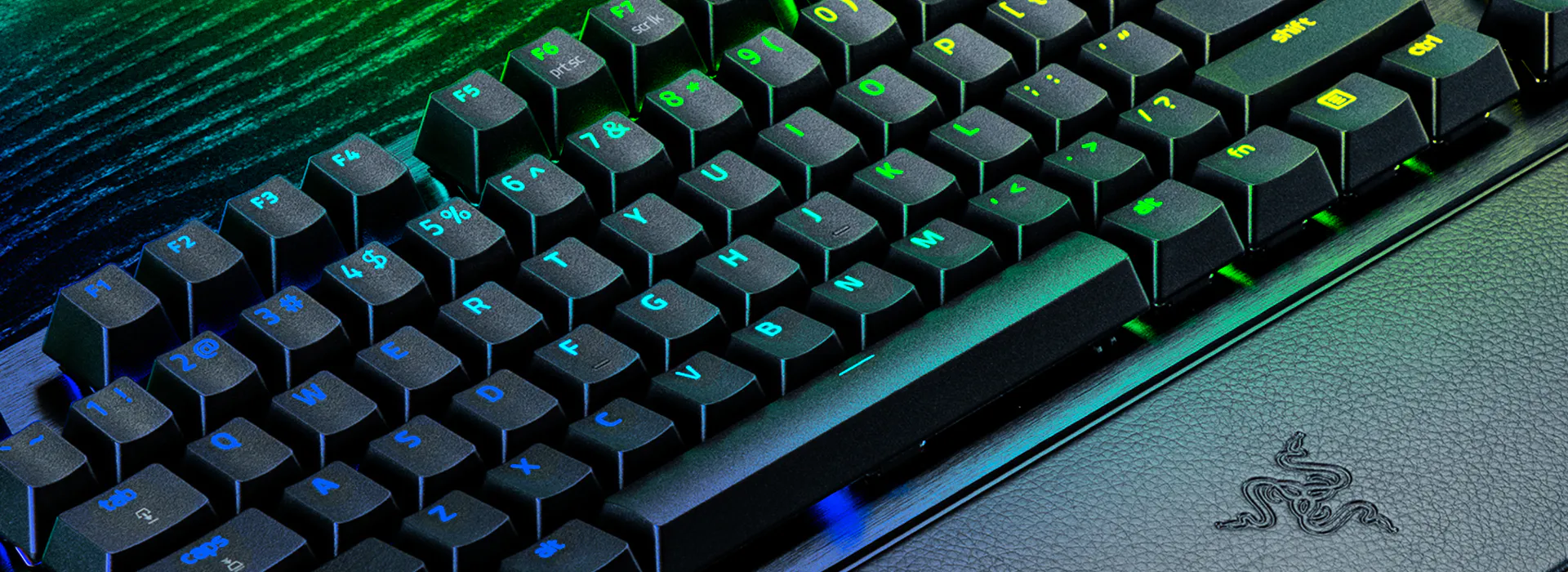 Custom RGB backlit black mechanical keyboard with green and blue lighting.