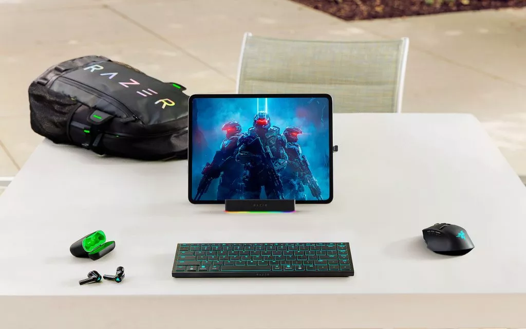 Level Up Your Portable Gaming Setup with the Razer Basilisk Mobile and Razer Joro Top-down view of the Razer Joro low-profile keyboard and Razer Basilisk Mobile mouse, both illuminated with green lighting on a dark surface.
