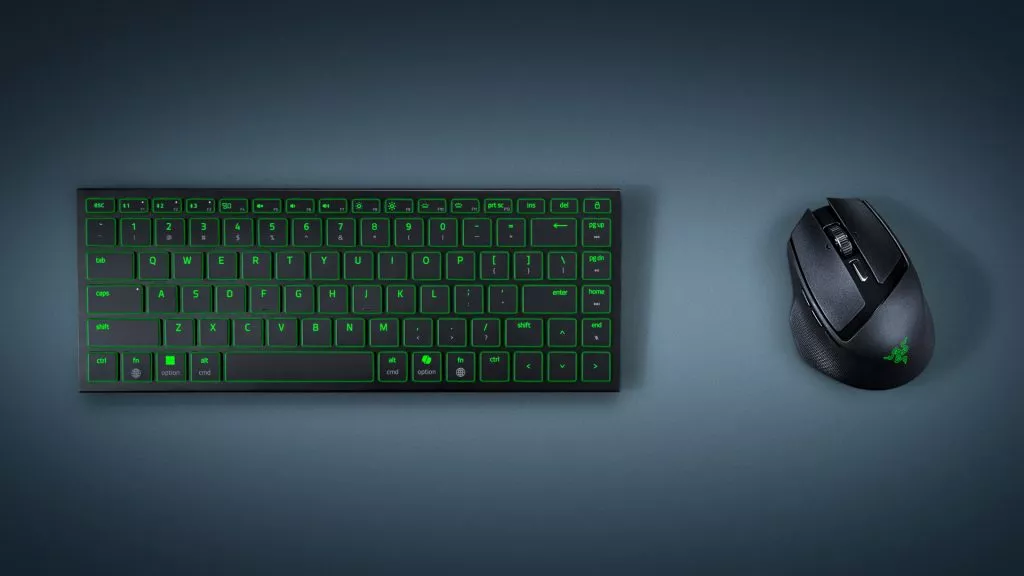 Top-down view of the Razer Joro low-profile keyboard and Razer Basilisk Mobile mouse, both illuminated with green lighting on a dark surface.