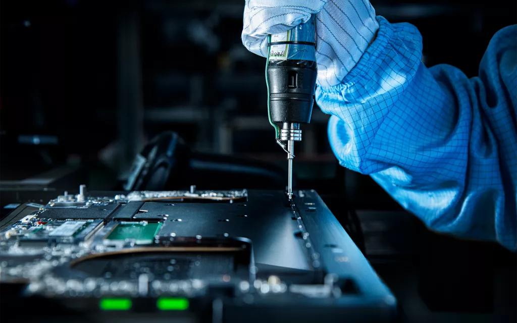 Razer Cooling Tech: Vapor Chamber vs Heat Pipes Close-up of a technician assembling a Razer Blade laptop, highlighting precision engineering and internal component assembly.