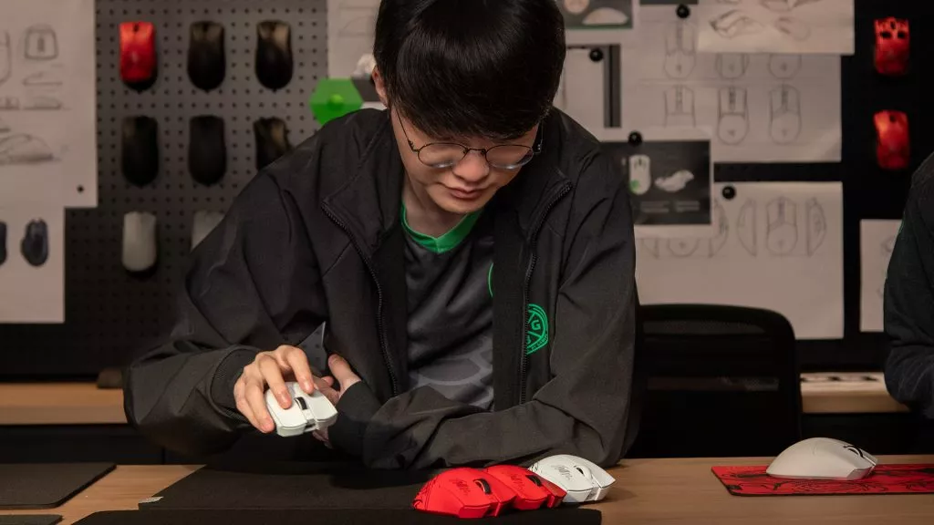 Faker testing Viper V3 pro at a workstation, comparing different designs and shapes for performance and comfort.