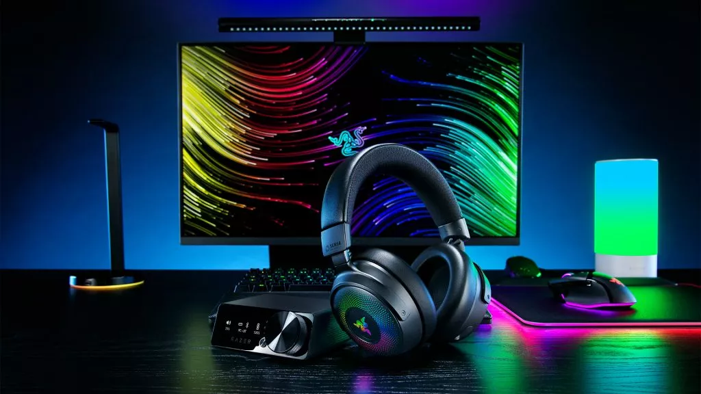 Razer Kraken V4 Pro headset with RGB lighting on a complete gaming desk setup.