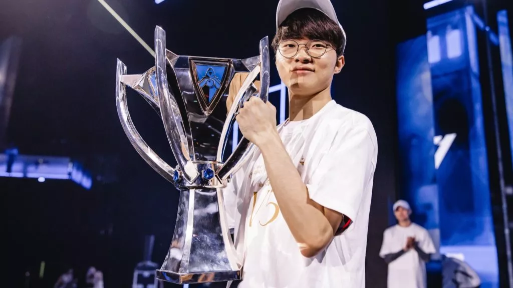 Faker holding the silver Summoner’s Cup trophy after winning the 2023 League of Legends World Championship