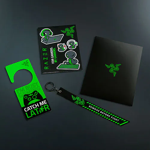 Razer L33t pack includes sticker sheet, keychain, and a green door hanger with slogans