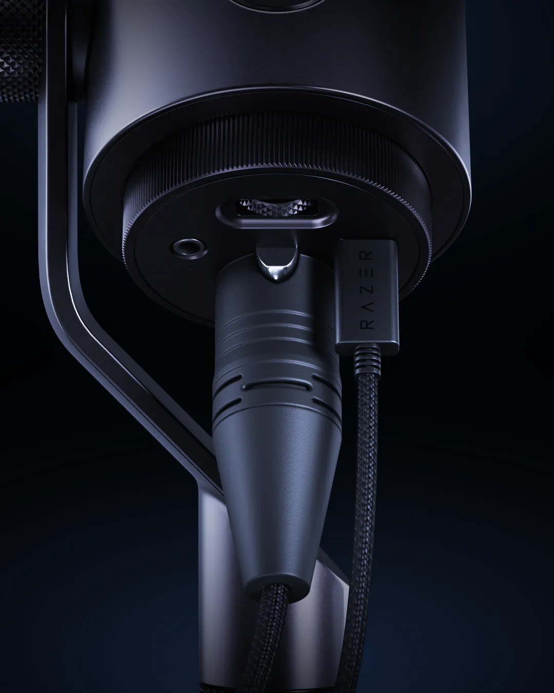 Close-up of a sleek, black Razer gaming microphone on a stand, with braided cable and minimalistic design against a dark background.