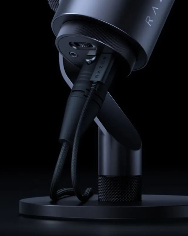 Close-up of a sleek, black Razer gaming microphone on a stand, with braided cable and minimalistic design against a dark background.