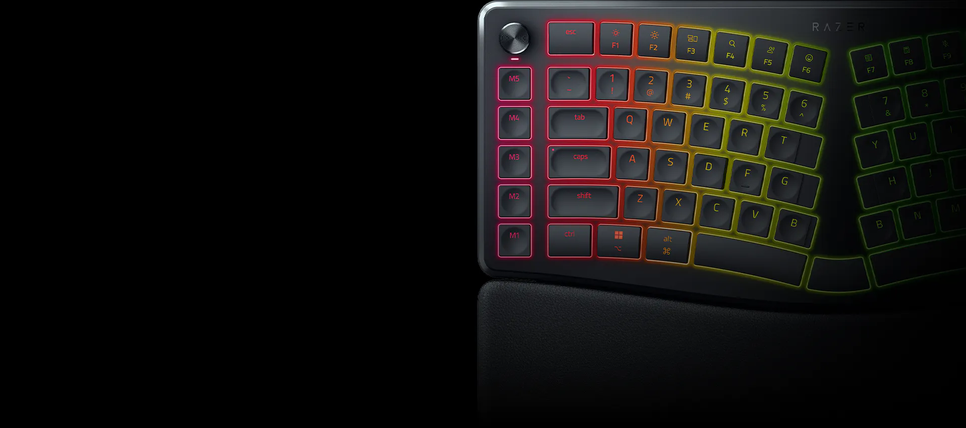 Close-up of a gaming keyboard with RGB backlit keys on a black surface, showing pink, orange, and yellow lighting effects.