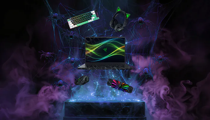 A gaming setup with a laptop displaying an Razer logo, surrounded by gaming accessories, controllers, and floating tech gadgets amid purple smoke.