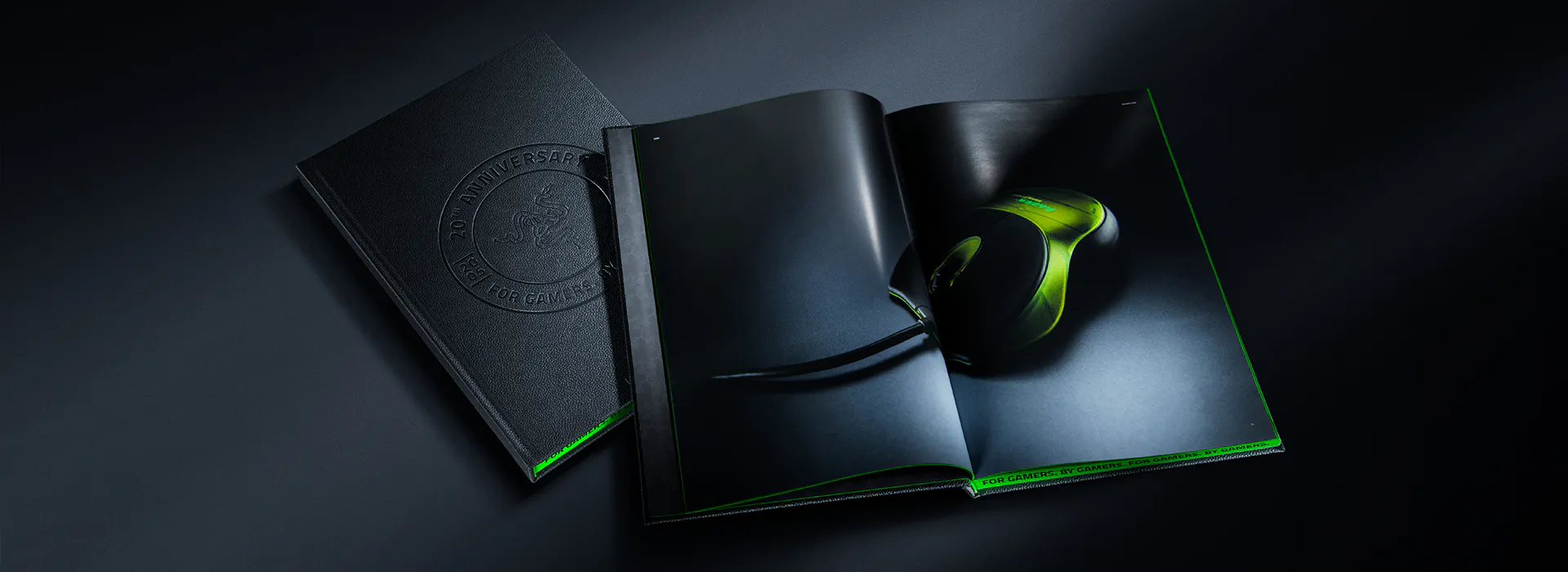 Open magazine with a Razer gaming mouse in an ad, showing black pages with green accents, and embossed "20th Anniversary" logo on cover.