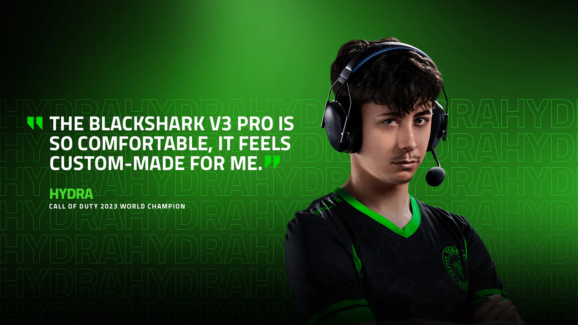 Young man in gaming headset, black Hydra jersey with green details, quote about comfort, and "Call of Duty 2023 World Champion" caption.