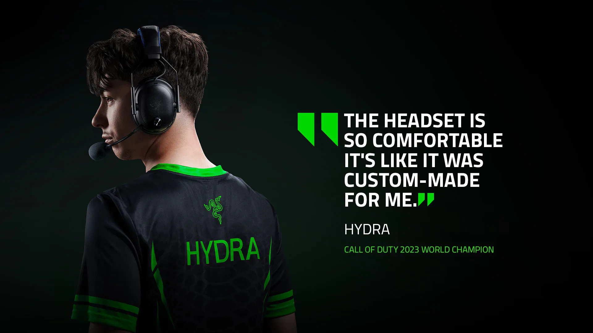 Young man in gaming headset, black Hydra jersey with green details, quote about comfort, and "Call of Duty 2023 World Champion" caption.