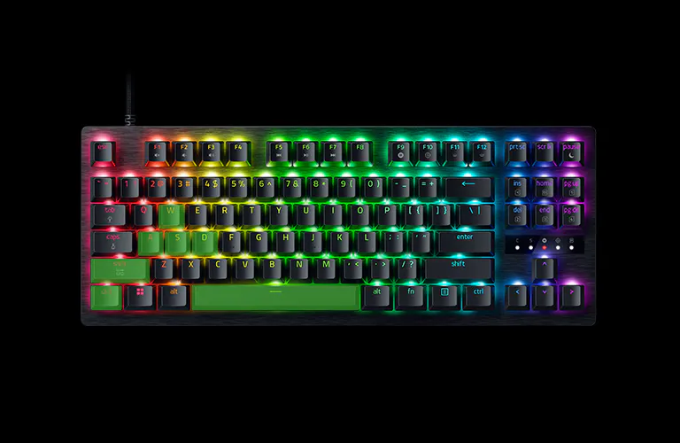 RGB backlit mechanical keyboard with black keys, colorful lighting under each key, labeled F1-F12, arrow keys, and numeric keypad.