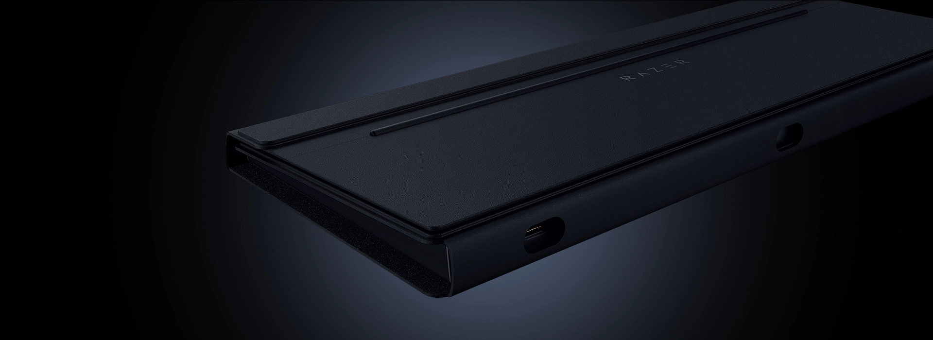 A sleek, black electronic device with the text "RAZER" on top, featuring a slim design, ports, and a textured surface, set against a dark background.