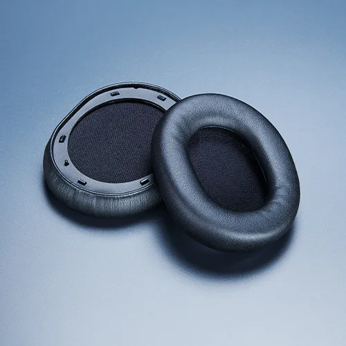 Pair of black headphone ear pads, one with foam padding and the other showing the interior mesh.