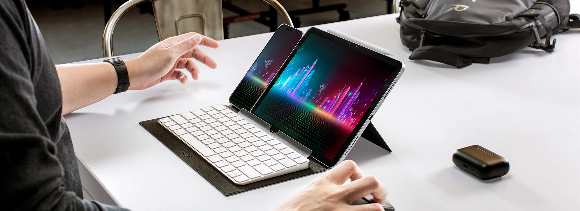 Tablet and phone held upright by a folding case stand, with a detachable keyboard in front, freeing both hands